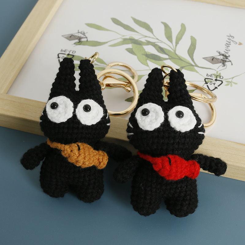 Two original big-eyed black cat crochet keychains with colorful neck bows