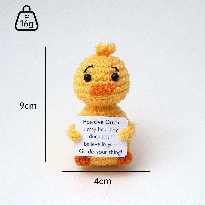 Small positive duck crochet companion holding an encouraging message card